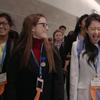two female students competing at a science fair, they are laughing and smiling