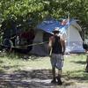 A homeless person walks to a tent under the Julia Tuttle Causeway in Miami, Wednesday, July 22, 2009.