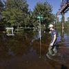 Zachary Conner wades into a flooded neighborhood to check on his girlfriend in Lumberton, N.C., Tuesday, Sept. 18, 2018, following the effects from Hurricane Florence.