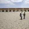 In this Tuesday, July 10, 2018 file photo, a woman and a boy walk on the dried up riverbed of the Zayandeh Roud river that no longer runs under the 400-year-old Si-o-seh Pol bridge in Isfahan, Iran