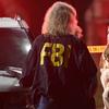 An FBI agent talks to a potential witness as they stand near the scene Thursday, Nov. 8, 2018, in Thousand Oaks, Calif.