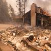 A firefighter keeps watch as the charred remains of a burned out home are seen during the Woolsey Fire in Malibu, Calif., Friday, Nov. 9, 2018.