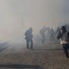 Migrants run from tear gas launched by U.S. agents, amid photojournalists covering the Mexico-U.S. border, after a group of migrants got past Mexican police at the Chaparral crossing in Tijuana