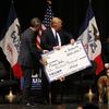 In this Jan. 30, 2016 file photo, Republican presidential candidate Donald Trump distributes a check to Puppy Jake during a campaign event at the Adler Theater in Davenport, Iowa.