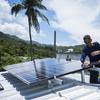 In this July 24, 2018 photo, Julio Rosario, left, instals a solar energy system with the founder of the nonprofit environmental group Casa Pueblo Alexis Masol