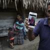 Domingo Caal Chub, 61, holds a smartphone displaying a photo of his granddaughter, Jakelin Amei Rosmery Caal Maquin, in Raxruha, Guatemala