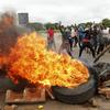 Protestors gather near a burning tire during a demonstration over the hike in fuel prices in Harare, Zimbabwe, Tuesday, Jan. 15, 2019. 