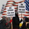 Teachers carry placards as they walk a picket line outside South High School early Monday, Feb. 11, 2019, in Denver. 