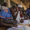 Electoral officials look through voter registration lists at a polling station in Kano, northern Nigeria Saturday, Feb. 23, 2019. 