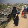 A Rohingya refugee family walks back with relief material collected from aid agencies inside Balukhali refugee camp near Cox's Bazar, in Bangladesh, Saturday, Nov. 17, 2018. 