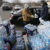 Volunteers load a vehicle with bottled water at Our Lady of Guadalupe Church, Friday, Feb. 5, 2016 in Flint, Mich. 