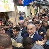 Israeli Prime Minister Benjamin Netanyahu escorted by bodyguards walks during a visit to the market on the eve of Israel's general elections in Jerusalem, Monday, April 8, 2019.
