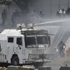 A Bolivarian National Guard water canon sprays opponents of Venezuela's President Nicolas Maduro during an attempted military uprising and anti-government protests in Caracas, Venezuela, Tuesday.