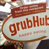A sign with the old Grubhub logo is displayed is displayed on the door to a New York restaurant. 