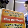 A Transportation Security Administration employee stands at a booth to learn about a food stamp program at a food drive at Newark Liberty International Airport, Wednesday, Jan. 23, 2019.
