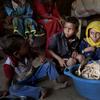 Children sit in front of moldy bread in their shelter, in Aslam, Hajjah, Yemen.