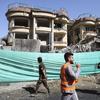 Afghan security forces walk in front of damaged buildings a day after an attack in Kabul, Afghanistan on May 9, 2019. 