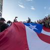 Demonstrators holding a giant Puerto Rico flag march against governor Ricardo Rosello, in San Juan, Puerto Rico, Wednesday, July 17, 2019. 