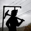 In this Oct. 16, 2014 file photo, fog hovers over a mountaintop as a cutout depicting a coal miner stands at a memorial to local miners killed on the job in Cumberland, Ky. 