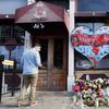A pedestrian passes a makeshift memorial for the slain and injured victims of a mass shooting that occurred in the Oregon District early Sunday morning, Wednesday, Aug. 7, 2019, in Dayton, Ohio.