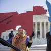 Activists at the Supreme Court opposed to partisan gerrymandering hold up representations of congressional districts from North Carolina, left, and Maryland, right.
