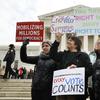 People rally outside of the Supreme Court in opposition to Ohio's voter roll purges, Wednesday, Jan. 10, 2018, in Washington.