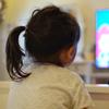a little girl watches a flat screen television