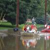 people on rescue boats going down a flooded street