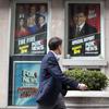 A pedestrian walks past the News Corp. headquarters building in New York displaying posters featuring Fox News Channel personalities including Bill O'Reilly, right, on Wednesday, April 19, 2017. 