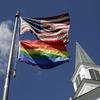 In this April 19, 2019, file photo, a gay pride rainbow flag flies along with the U.S. flag in front of the Asbury United Methodist Church in Prairie Village, Kan.