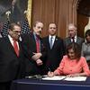 House Speaker Nancy Pelosi of Calif., signs the resolution to transmit the two articles of impeachment against President Donald Trump to the Senate for trial.