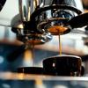an espresso machine dripping espresso into a cup