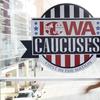 A pedestrian walks past a sign for the Iowa Caucuses on a downtown skywalk, Tuesday, Feb. 4, 2020, in Des Moines, Iowa.