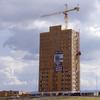 An 18-story tall wood building with a crane above it