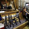 In this Oct. 20, 2017 file photo, Johnny's Auction House owner John West prepares items, including a line of assault rifles at left, for auction where the company handles gun sales for both civilians.