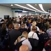 In this Saturday, March 15, 2020, photo, travelers wait in line to go through customs at O'Hare International Airport in Chicago.