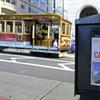 A newspaper headline announcing the closure of large events is displayed as a cable car goes down California Street, Friday, March 13, 2020, in San Francisco. 