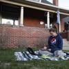 Lisa Condor sits on a blanket in her front yard as she works online on her masters in business administration from Colorado State University as a statewide stay-at-home order remains in effect in CO.