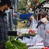 A boy wearing protective face masks to protect from the coronavirus picks out a bag of fresh produce at the North Hollywood Farmer's Market in Los Angeles on Saturday, April 4, 2020.