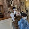 A child gets a haircut at a barber shop in Madrid, Spain, Monday, May 4, 2020. 