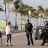 In this May 13 2020 file photo, Hollywood police officers monitor activity along the Hollywood Beach Broadwalk during the new coronavirus pandemic in Hollywood, Fla. 