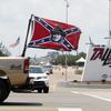A truck flying confederate flags passes the main entrance to Talladega Superspeedway Sunday, June 21, 2020, in Talladega, Ala. 