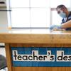 Des Moines Public Schools custodian Joel Cruz cleans a teacher's desk in a classroom at Brubaker Elementary School, Wednesday, July 8, 2020, in Des Moines, Iowa.