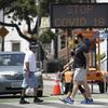 Pedestrians wear masks as they cross a street amid the coronavirus pandemic Sunday, July 12, 2020, in Santa Monica, Calif. 