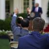 Reporters raise their hands to ask questions as President Donald Trump speaks during a news conference in the Rose Garden of the White House, Tuesday, July 14, 2020, in Washington.