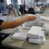 A worker gathers a bundle of ballots as they are processed at a Board of Elections facility, Wednesday, July 22, 2020, in New York.
