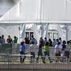 In this Feb. 19, 2019, file photo, children line up to enter a tent at the Homestead Temporary Shelter for Unaccompanied Children in Homestead, Fla.