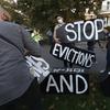 Housing activists erect a sign in front of Massachusetts Gov. Charlie Baker's house, Wednesday, Oct. 14, 2020, in Swampscott, Mass. 