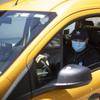 Taxi driver Nicolae Hent, wearing a protective mask, drives his taxi in New York, Monday, April 6, 2020. 