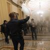 n this Wednesday, Jan. 6, 2021 file photo smoke fills the walkway outside the Senate Chamber as supporters of President Donald Trump are confronted by U.S. Capitol Police officers inside the Capitol i